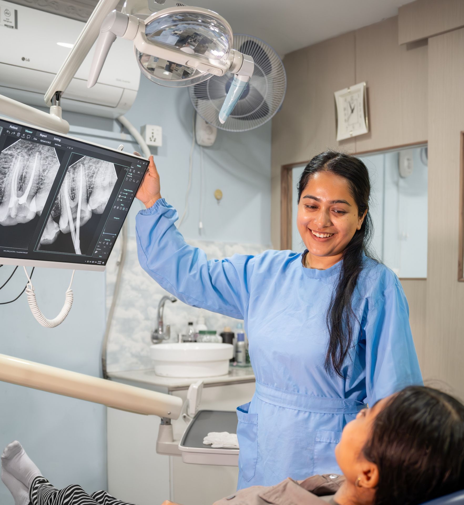 Polycare dentist reviewing dental X-rays with a patient